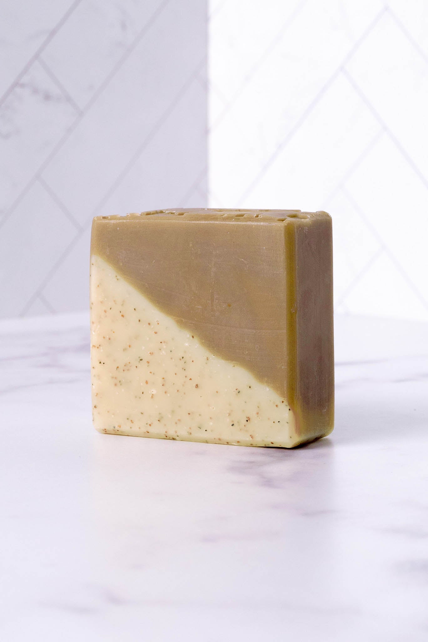 Rustic Strength sandalwood and patchouli bar soap showing a rectangular soap bar with earthy tones and natural texture.