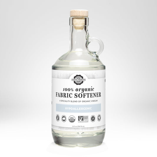 Rustic Strength Organic Fabric Softener in a 24 oz glass bottle, used for laundry to soften clothes naturally.