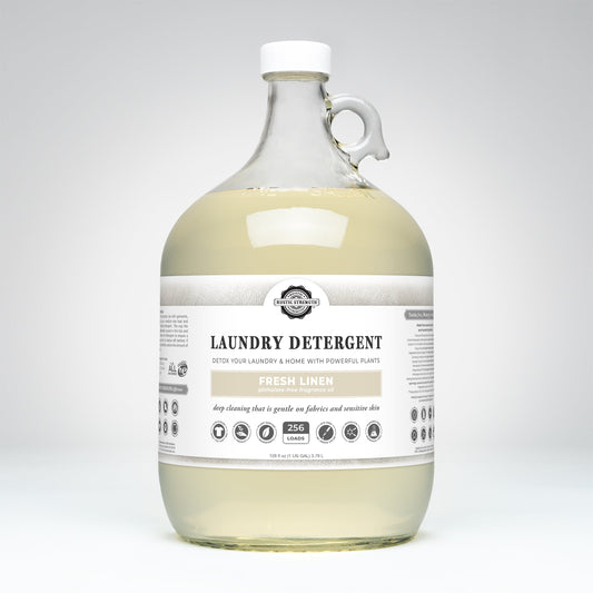 Rustic Strength Fresh Linen laundry detergent in a 24 oz glass bottle with a white cap, designed for clean, fresh-smelling laundry.