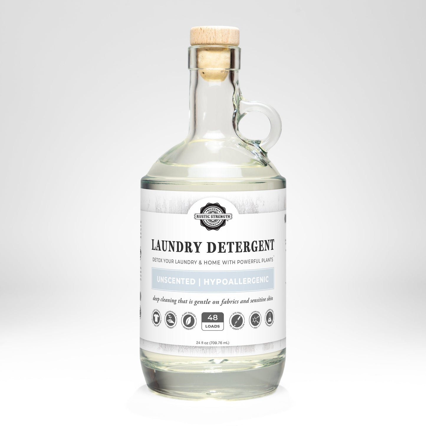 Rustic Strength unscented laundry detergent in a 24 oz glass bottle, showcasing the clear label and cap on a clean surface.