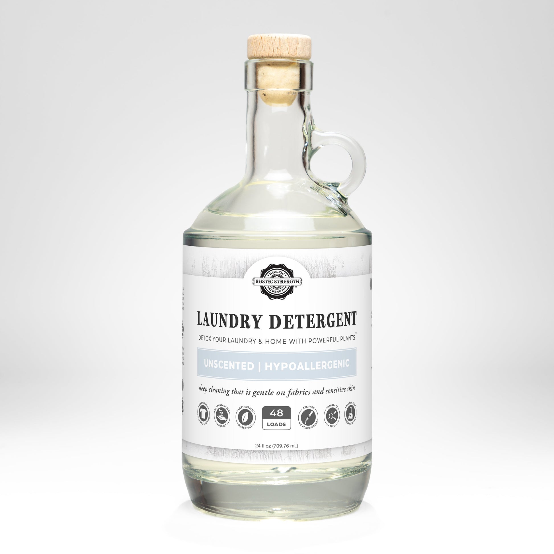 Rustic Strength unscented laundry detergent in a 24 oz glass bottle, showcasing the clear label and cap on a clean surface.