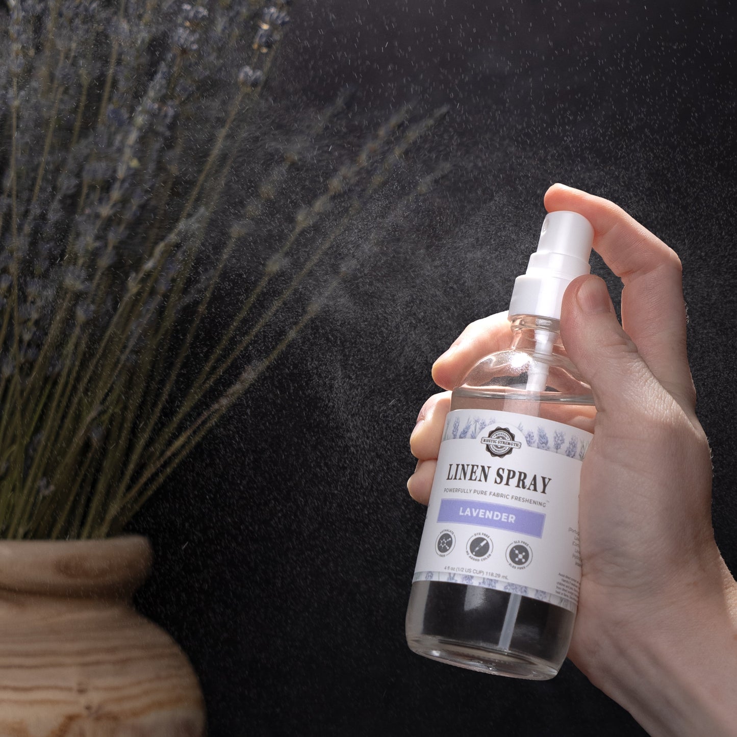 Rustic Strength lavender linen spray bottle with a white cap and label, designed to freshen fabrics with floral lavender scent.