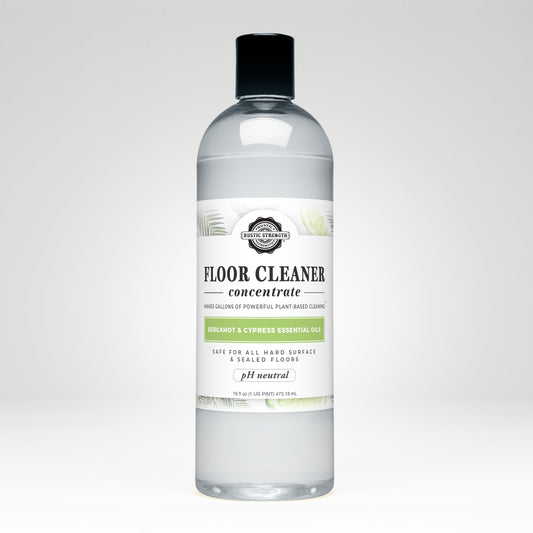 Rustic Strength Floor Cleaner Concentrate soap with bergamot and cypress scent in a 16 oz plastic bottle with flip-top spout.