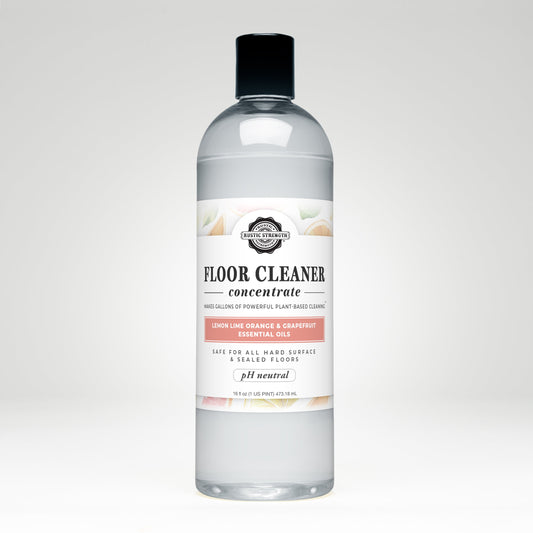 Rustic Strength Floor Cleaner Concentrate in 16 oz plastic bottle with flip-top spout, featuring lemon, lime, orange, and grapefruit scents.