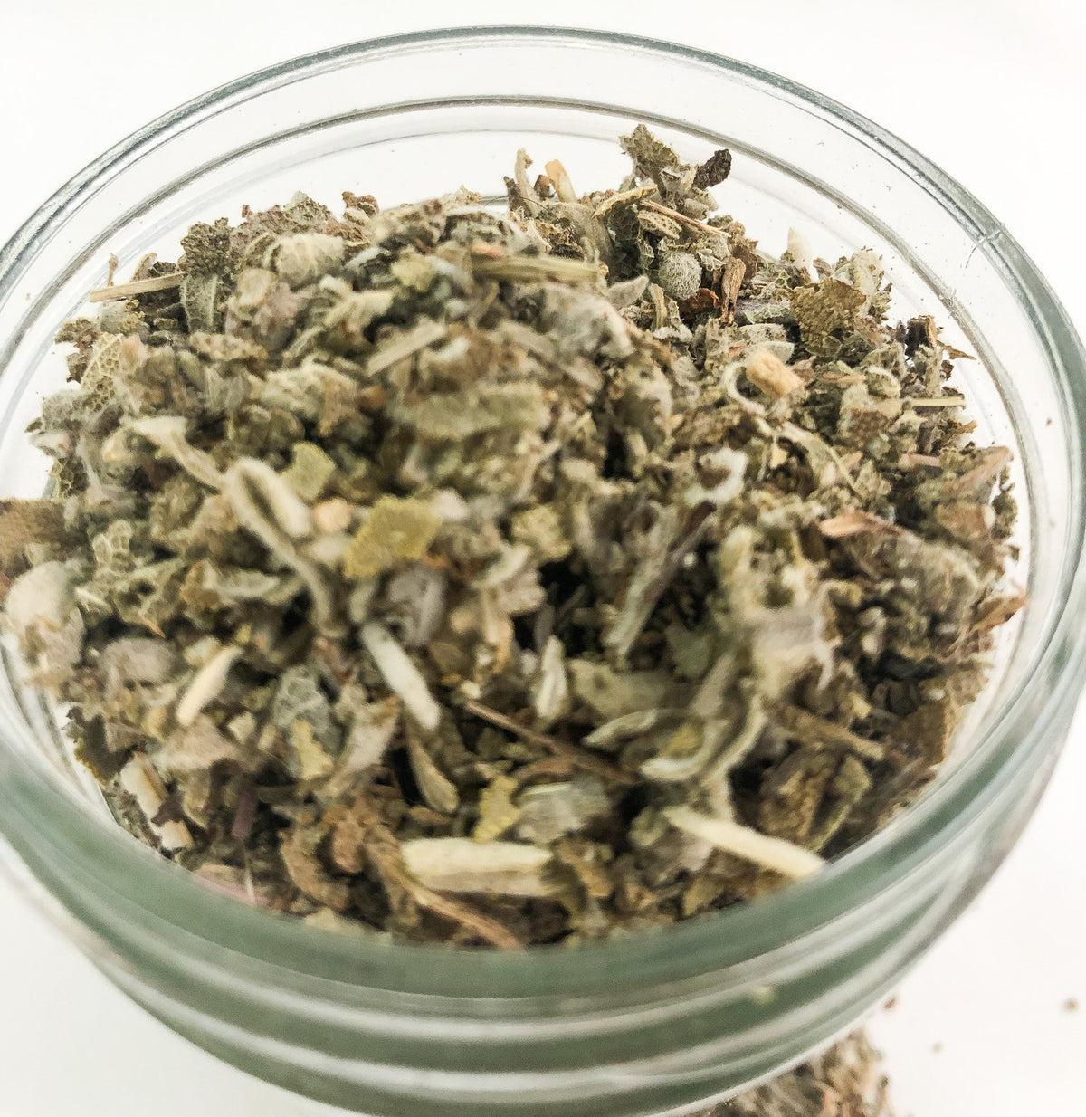 Small white jar of dried sage herbs in a herbalroseapothecary herb jar, perfect for herbal remedies and natural cooking.