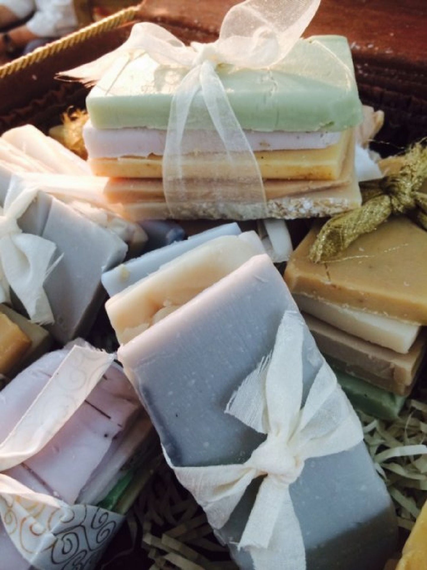 Assorted organic handmade soap bars from Sweet Harvest Farms in a sample pack, showcasing natural textures and earthy colors.