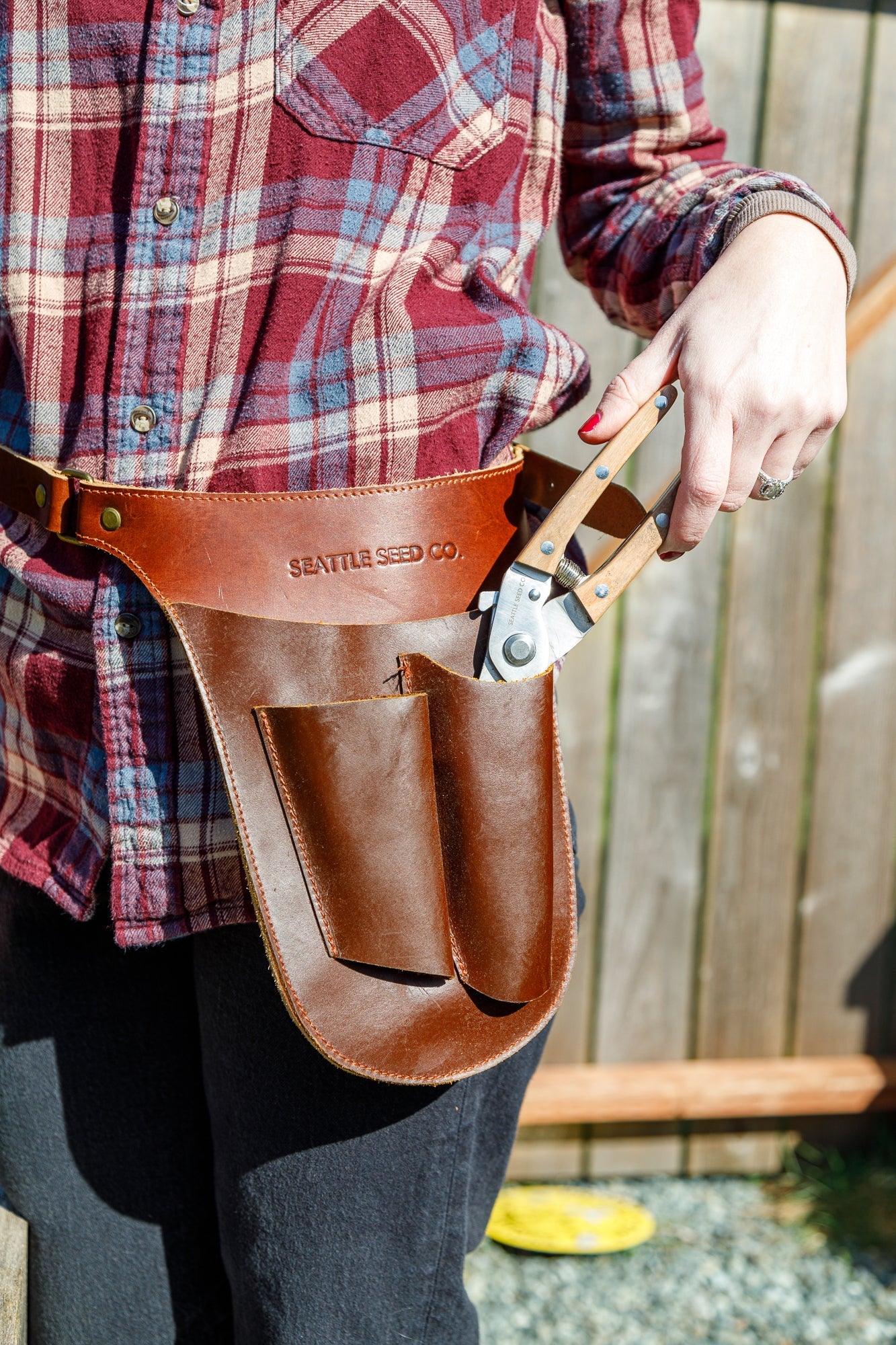 Genuine leather gardener's tool belt by Seattle Seed Company, with multiple pouches for gardening tools and accessories.