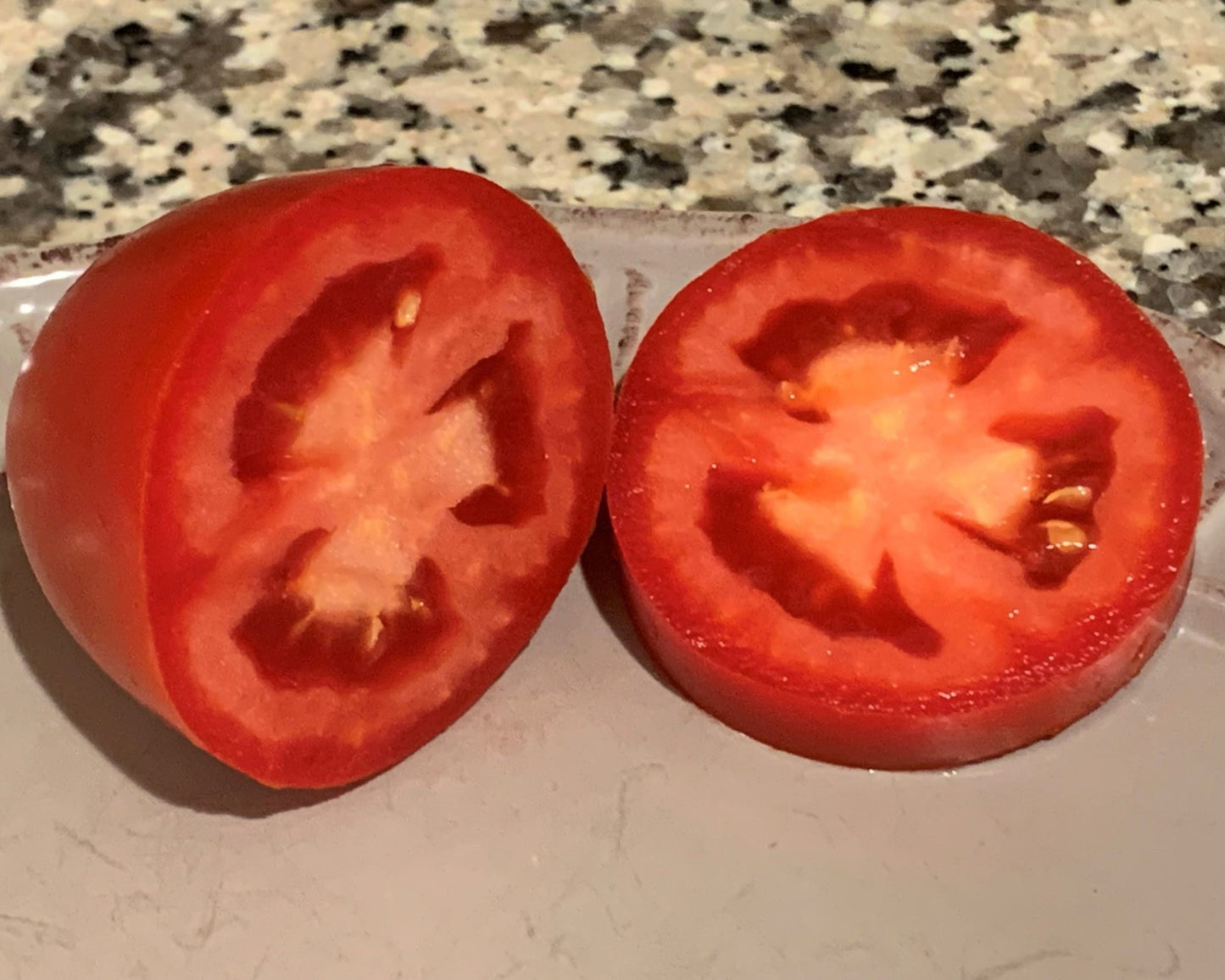 Packet of Zenzei Hybrid Tomato Seeds from Seeds 'n Such, showing 8-10 seeds in the packet for planting.