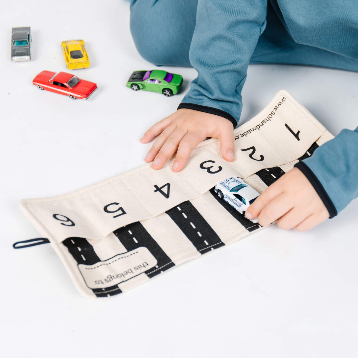 Colorful toy car storage playmat by So Handmade Shop, designed for organizing toy cars at home or on the go.