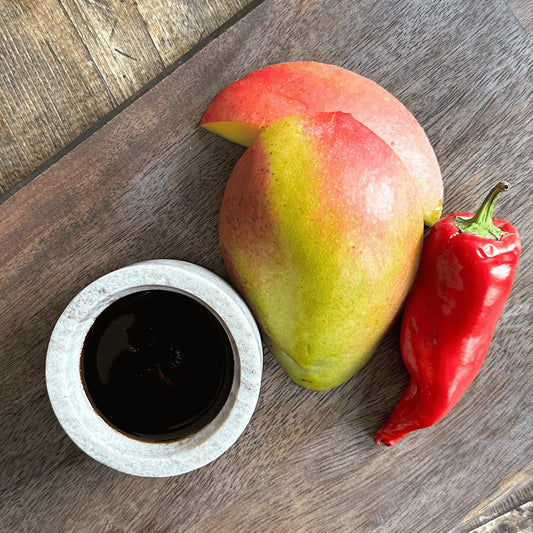 Dark balsamic vinegar bottle from Olive Branch Oil & Spice featuring Spicy Mango Aged Dark Balsamic Vinegar with a dark glass container and label