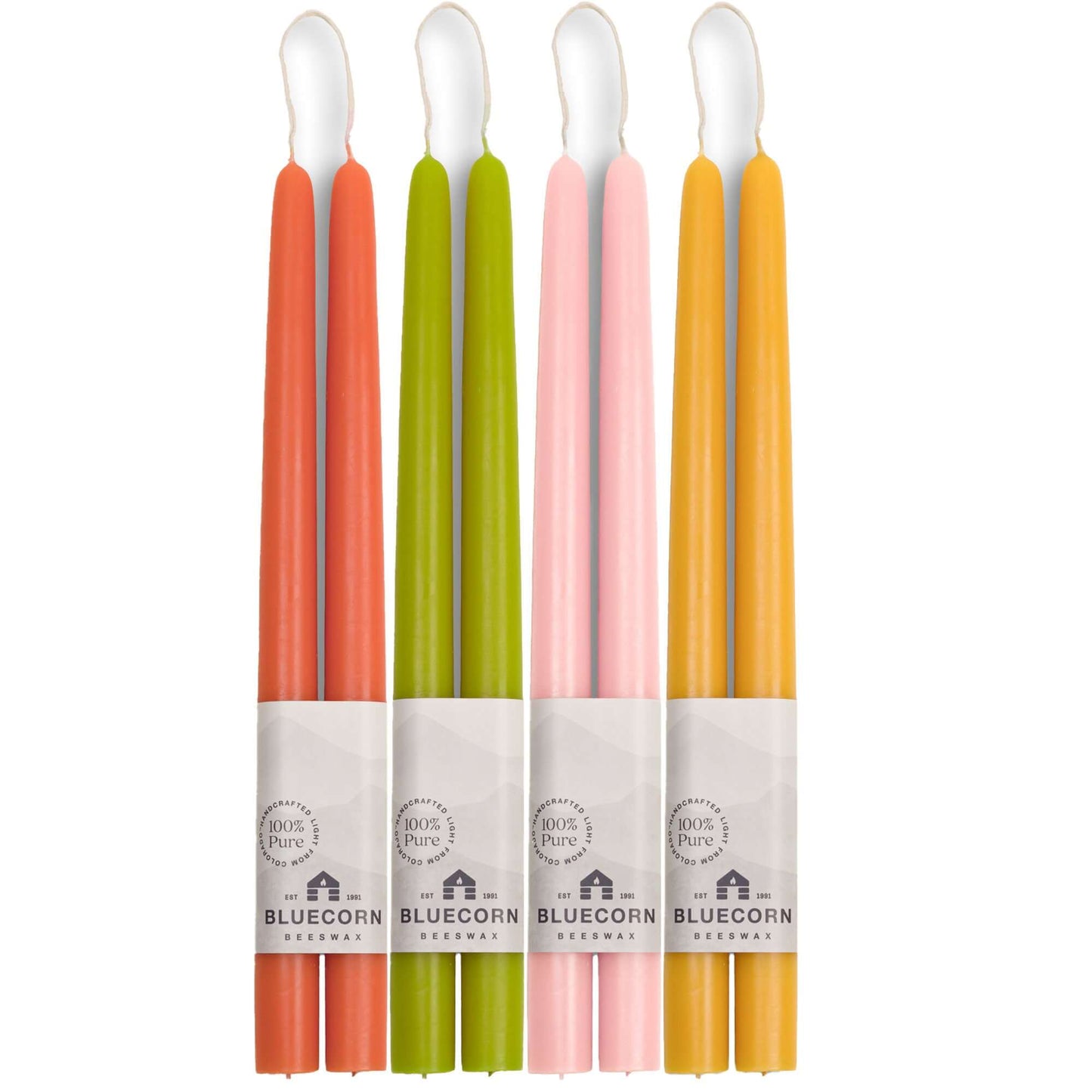 Set of Bluecorn Candles beeswax taper candles in dusty rose, apricot, pistachio, and raw colors, arranged together.