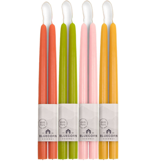 Set of Bluecorn Candles beeswax taper candles in dusty rose, apricot, pistachio, and raw colors, arranged together.