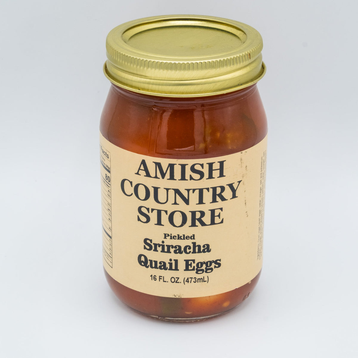 Canned pickled Sriracha quail eggs from Amish Country Store in a jar, showcasing bright red Sriracha sauce coated eggs.