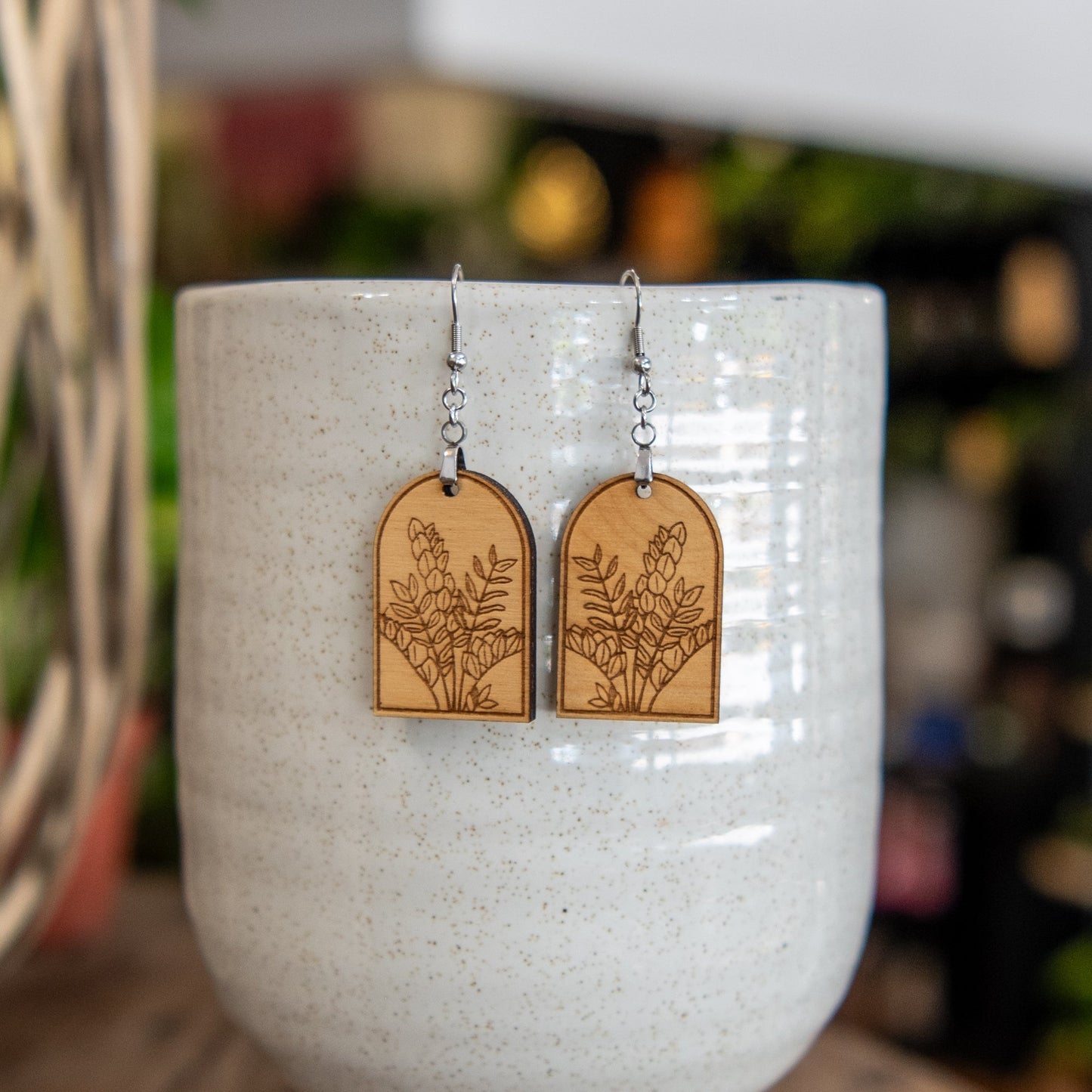 Still Magnolia ZZ Plant Arched Earrings featuring delicate leaf-shaped silver earrings with a modern, elegant design.