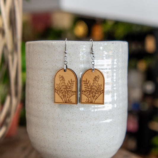 Still Magnolia ZZ Plant Arched Earrings featuring delicate leaf-shaped silver earrings with a modern, elegant design.