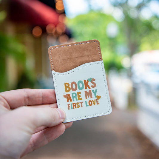 Still Magnolia Books Are My First Love phone wallet featuring a floral design and card slots, made of durable material.