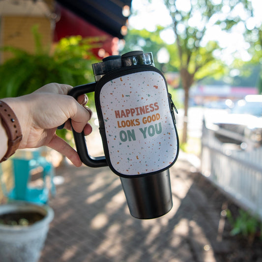 Still Magnolia tumbler pouch with "Happiness Looks Good on You" print, designed to hold and protect your tumbler or drinkware.