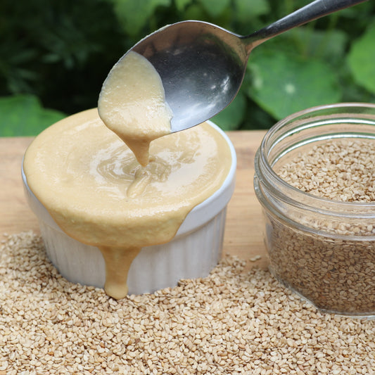 Creamy organic tahini in a jar, showcasing East Wind Crafts' organic tahini product with a smooth, light beige texture.