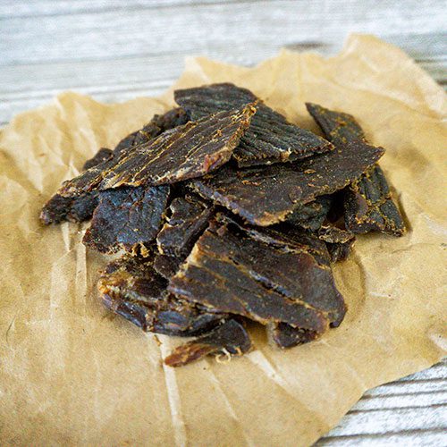 Thin slices of Teriyaki Beef Jerky from Nebraska Star Beef displayed in a 1.5 oz package, showcasing the glazed, flavorful meat.
