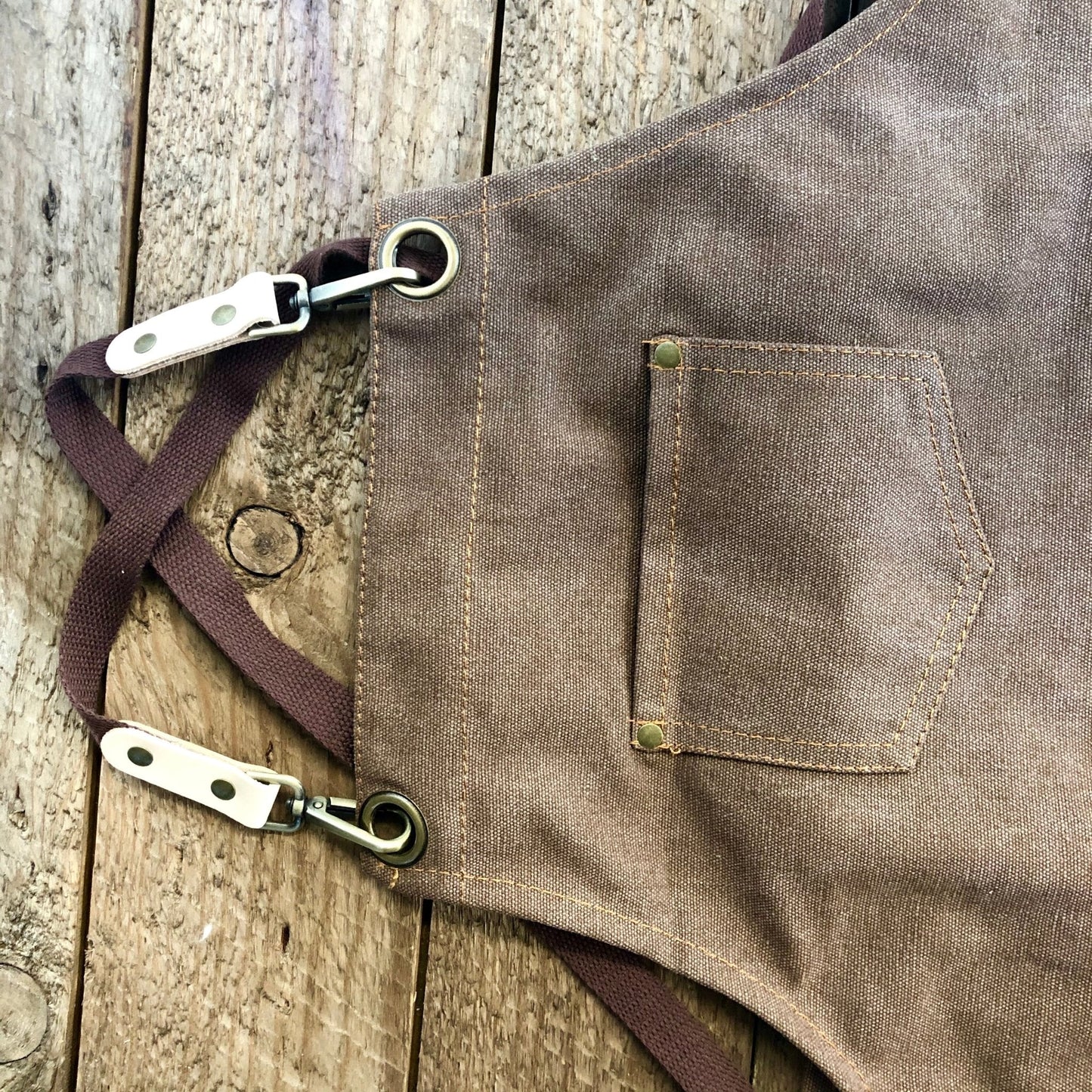 Dark green waxed canvas gardening apron with multiple pockets from The Celtic Farm, designed for outdoor gardening tasks.