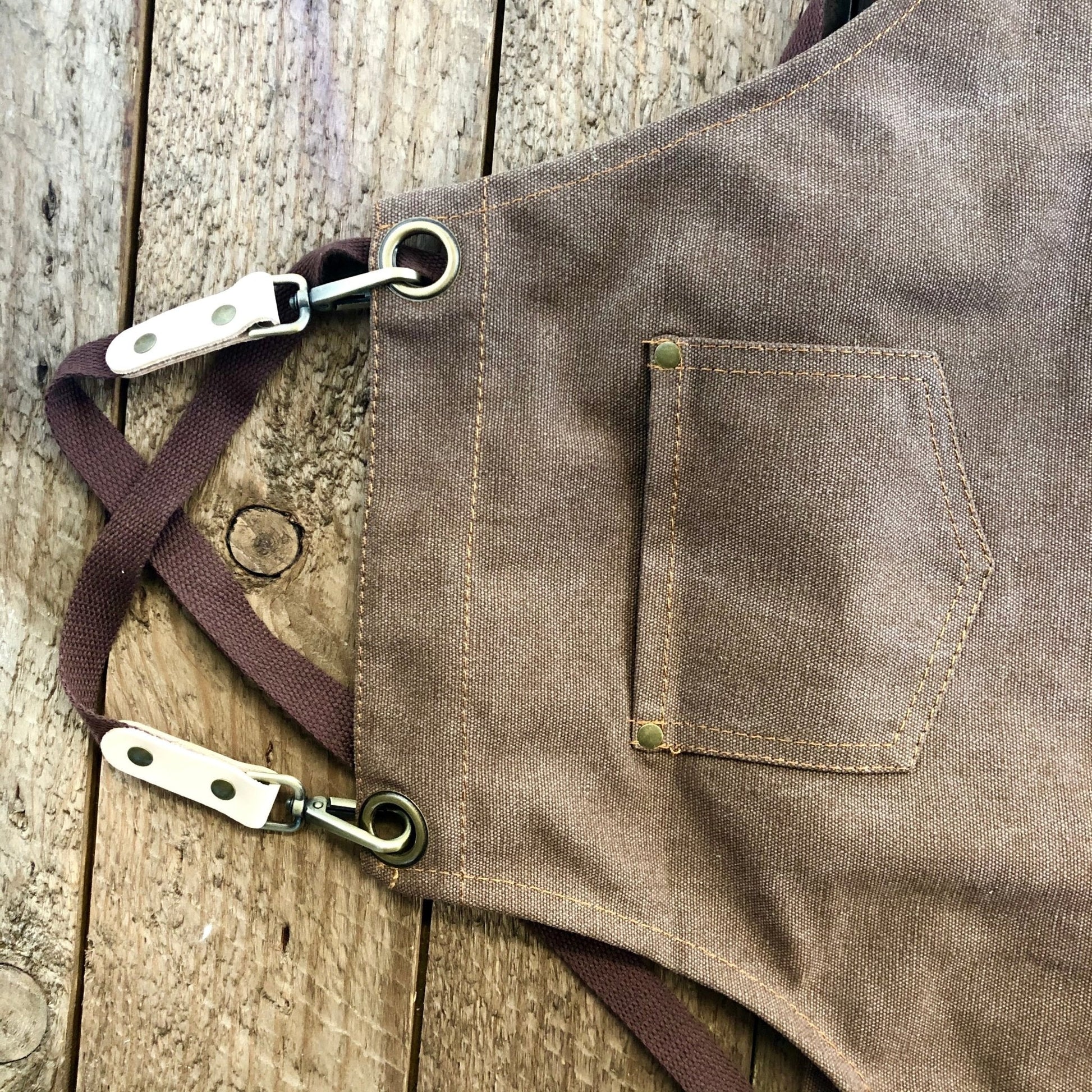 Dark green waxed canvas gardening apron with multiple pockets from The Celtic Farm, designed for outdoor gardening tasks.