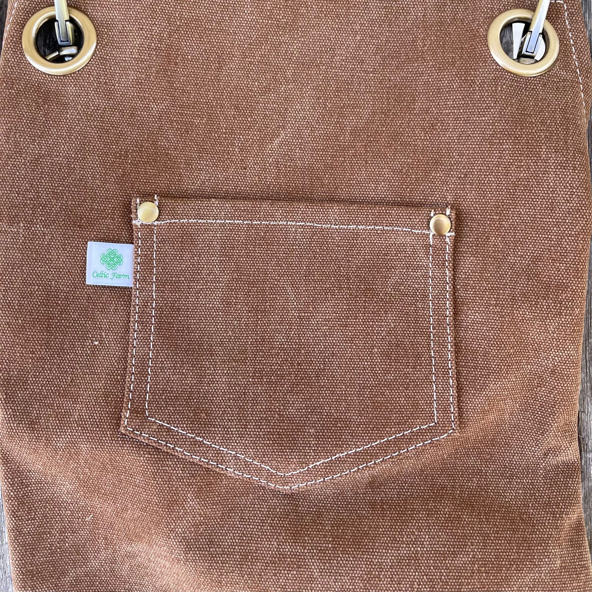 Dark green waxed canvas gardening apron with multiple pockets from The Celtic Farm, ideal for gardening and outdoor work.