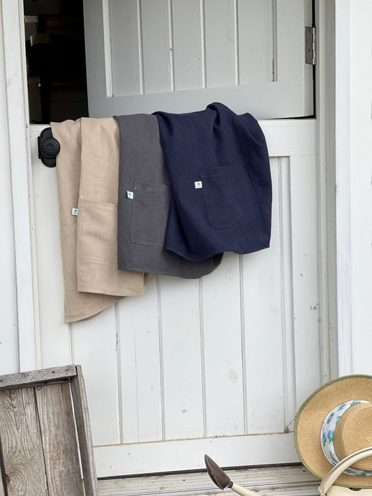 Sand linen apron by The Celtic Farm featuring a French style crossback design, ideal for cooking or baking.