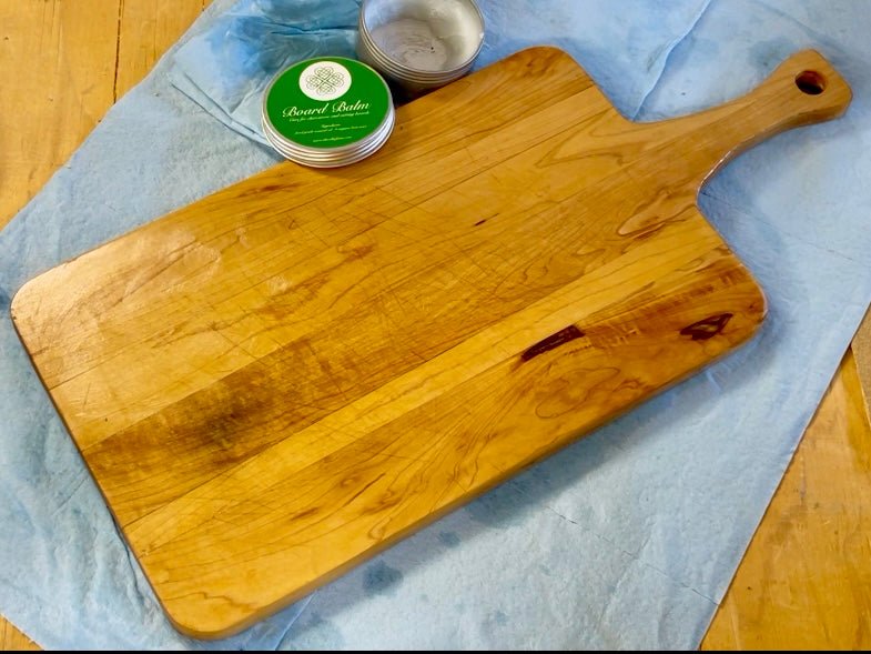 The Celtic Farm Board Balm for cutting and charcuterie boards, showing a jar of oil and wax treatment on a wooden board.