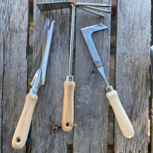 The Celtic Farm garden gift box with a unique garden tool set, including gardening trowel and hand rake, displayed on a wooden surface.