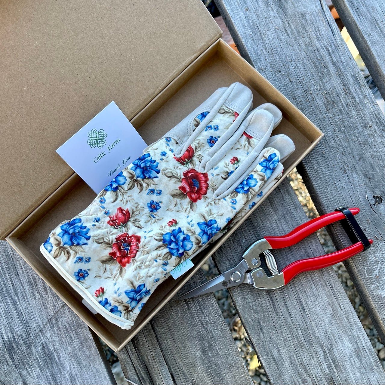 The Celtic Farm garden gift box with green and yellow gardening gloves and needle snips for gardening tasks.