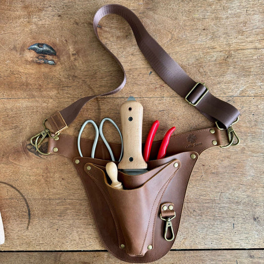 The Celtic Farm leather garden tool belt with extra rivet reinforcement, designed for master gardeners, shown with multiple tool holders.