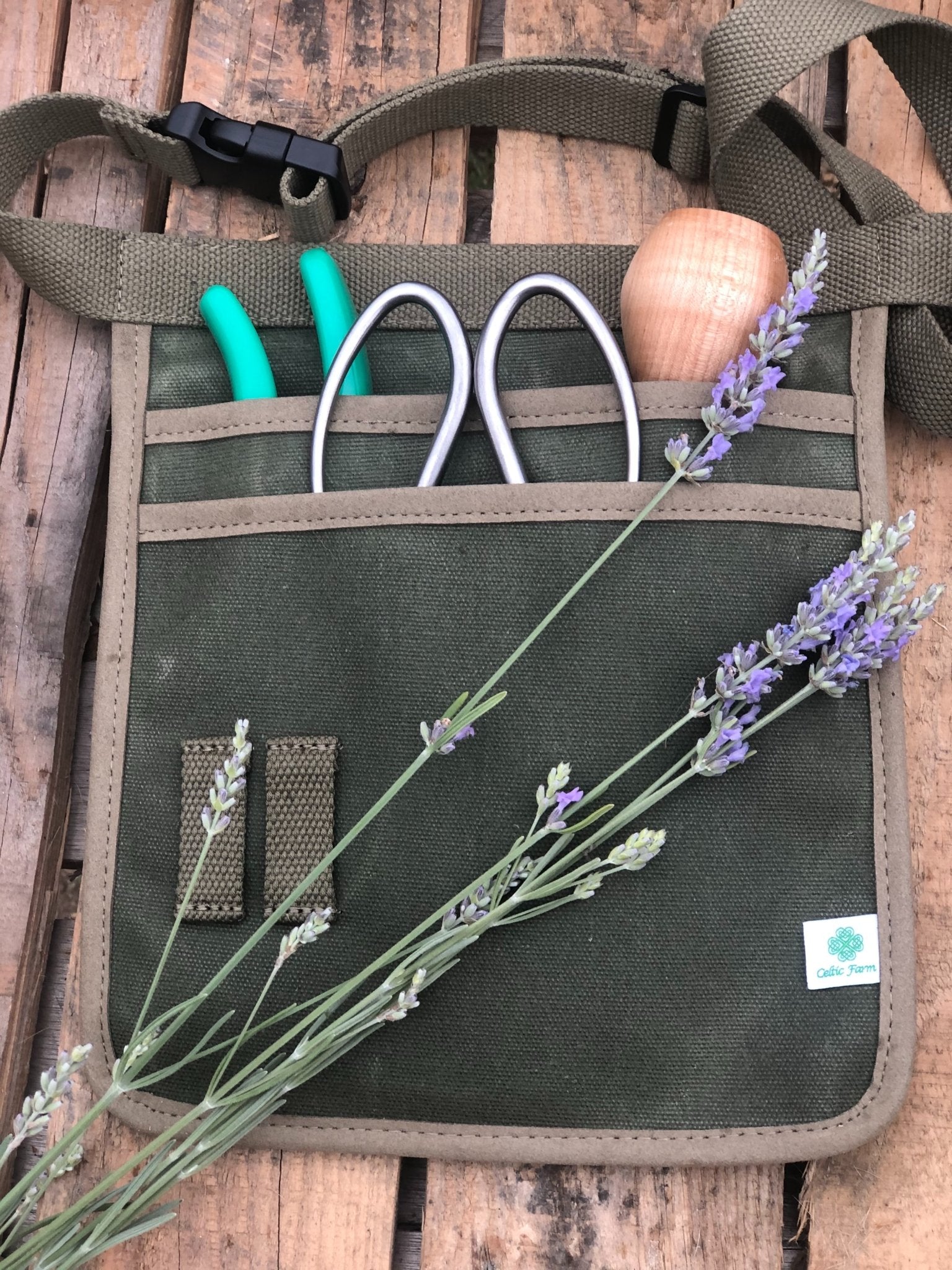 The Celtic Farm waxed canvas garden tool belt in hunter green with multiple pockets for gardening tools and accessories.