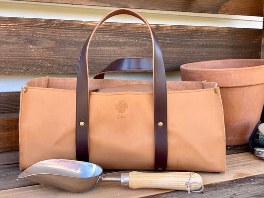 Leather gardener's tool bag by The Celtic Farm with multiple compartments and sturdy handles for gardening tools.