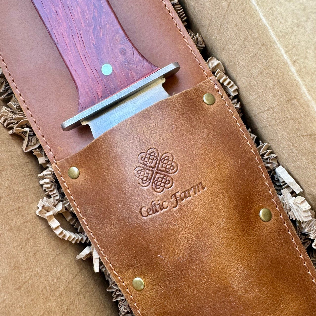 The Celtic Farm Hori Hori garden tool in a gift box, featuring a versatile gardening knife with wooden handle and protective sheath.