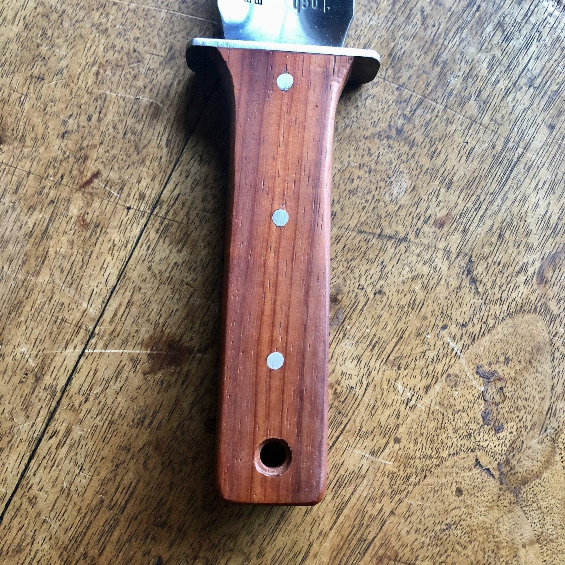 The Celtic Farm Hori Hori garden tool in a gift box, featuring a sharp blade, wooden handle, and gardening accessories.