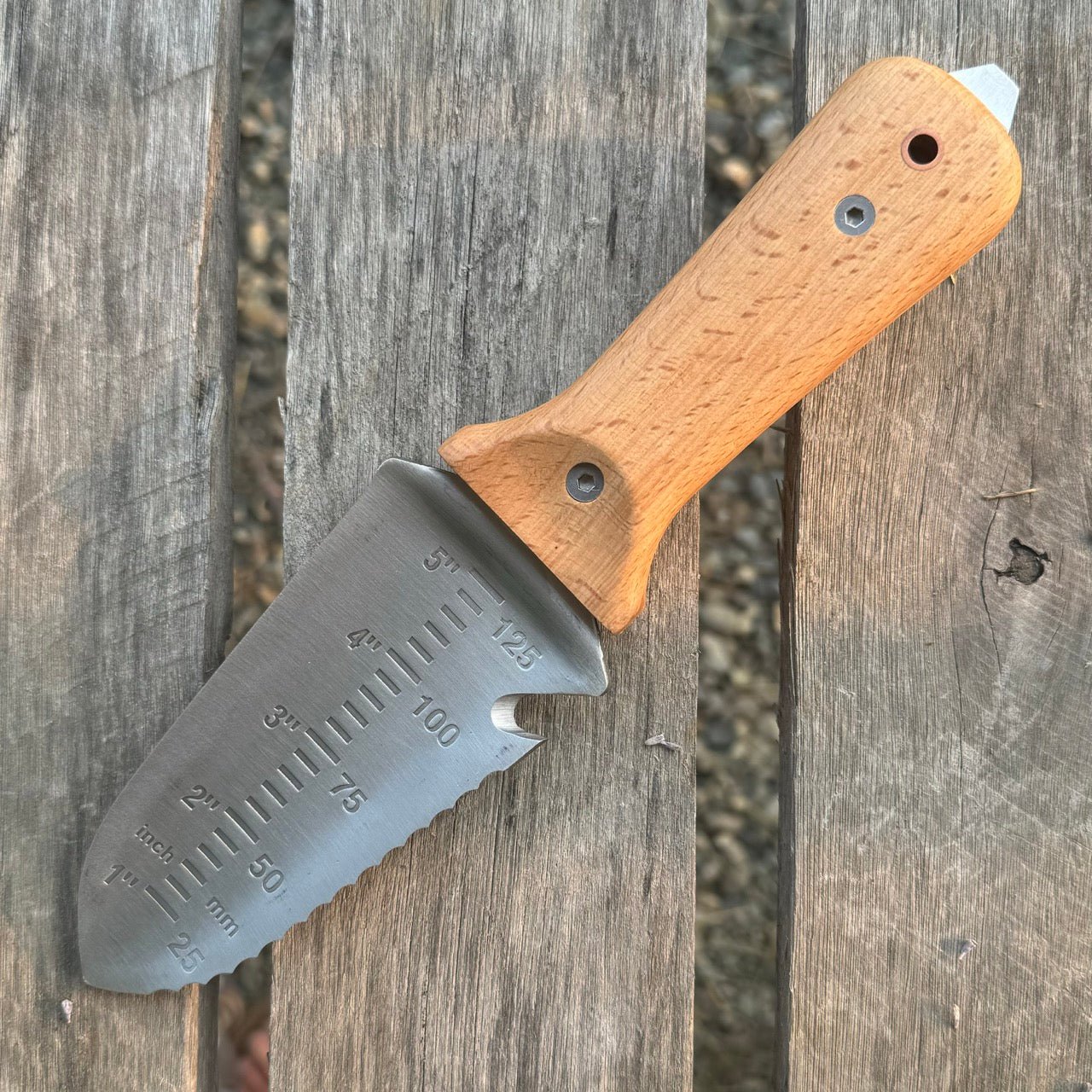 The Celtic Farm Tanto Hori Hori garden tool with a sharp blade and wooden handle for digging and gardening tasks.