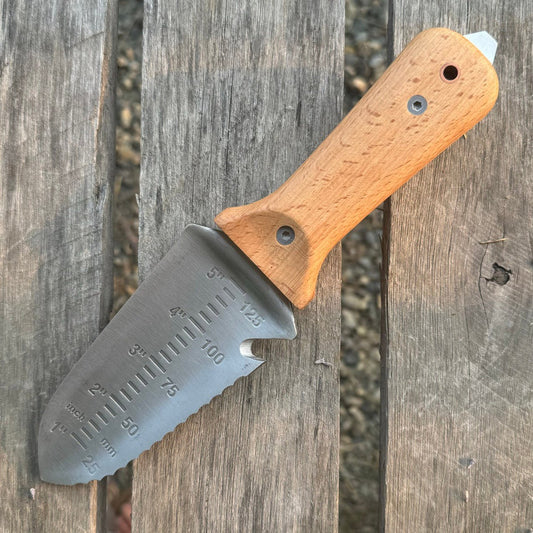 The Celtic Farm Tanto Hori Hori garden tool with a sharp blade and wooden handle for digging and gardening tasks.