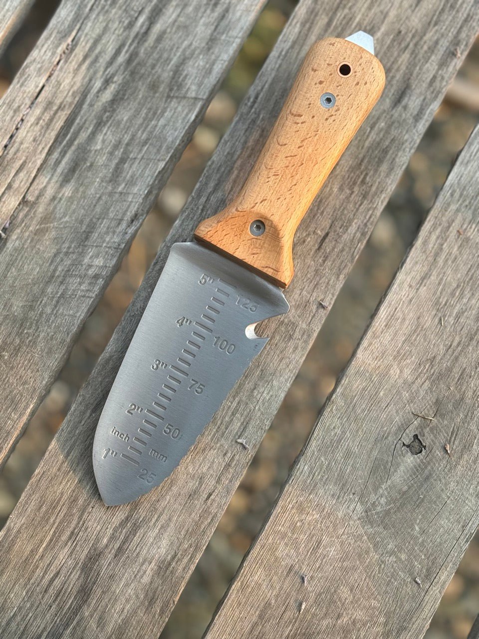Celtic Farm Tanto Hori Hori garden tool with wooden handle and sharp blade for planting, digging, and weeding in the garden.