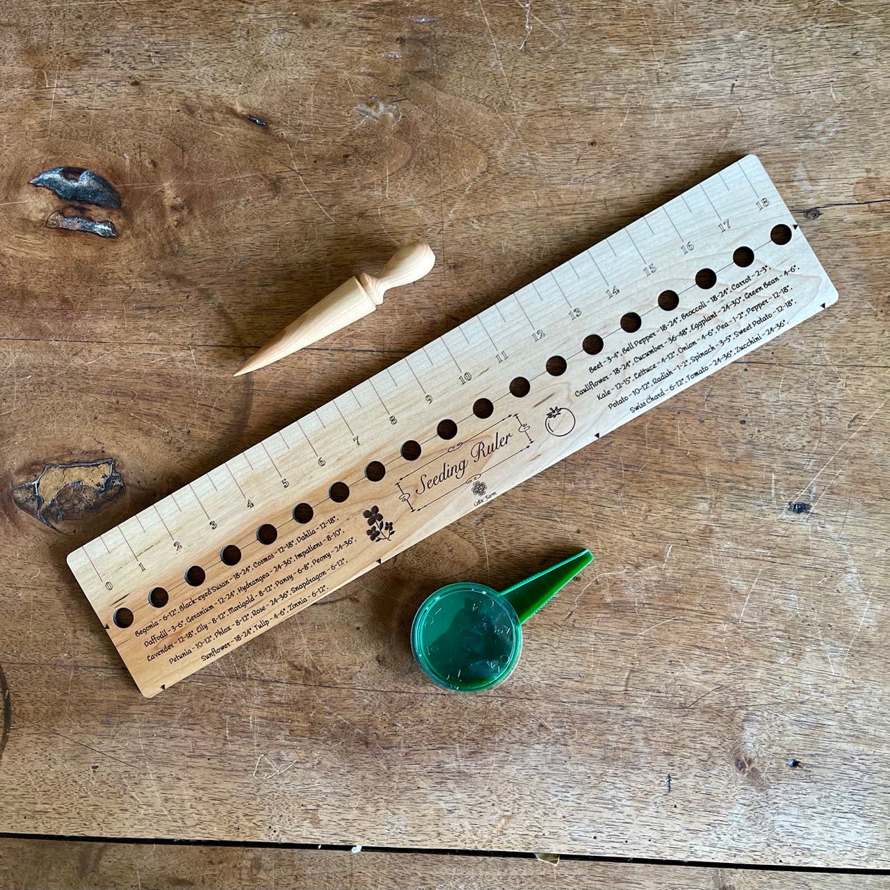 The Celtic Farm Seeding Gift Set with dibble, seed seeder, and ruler tools for gardening and planting tasks.