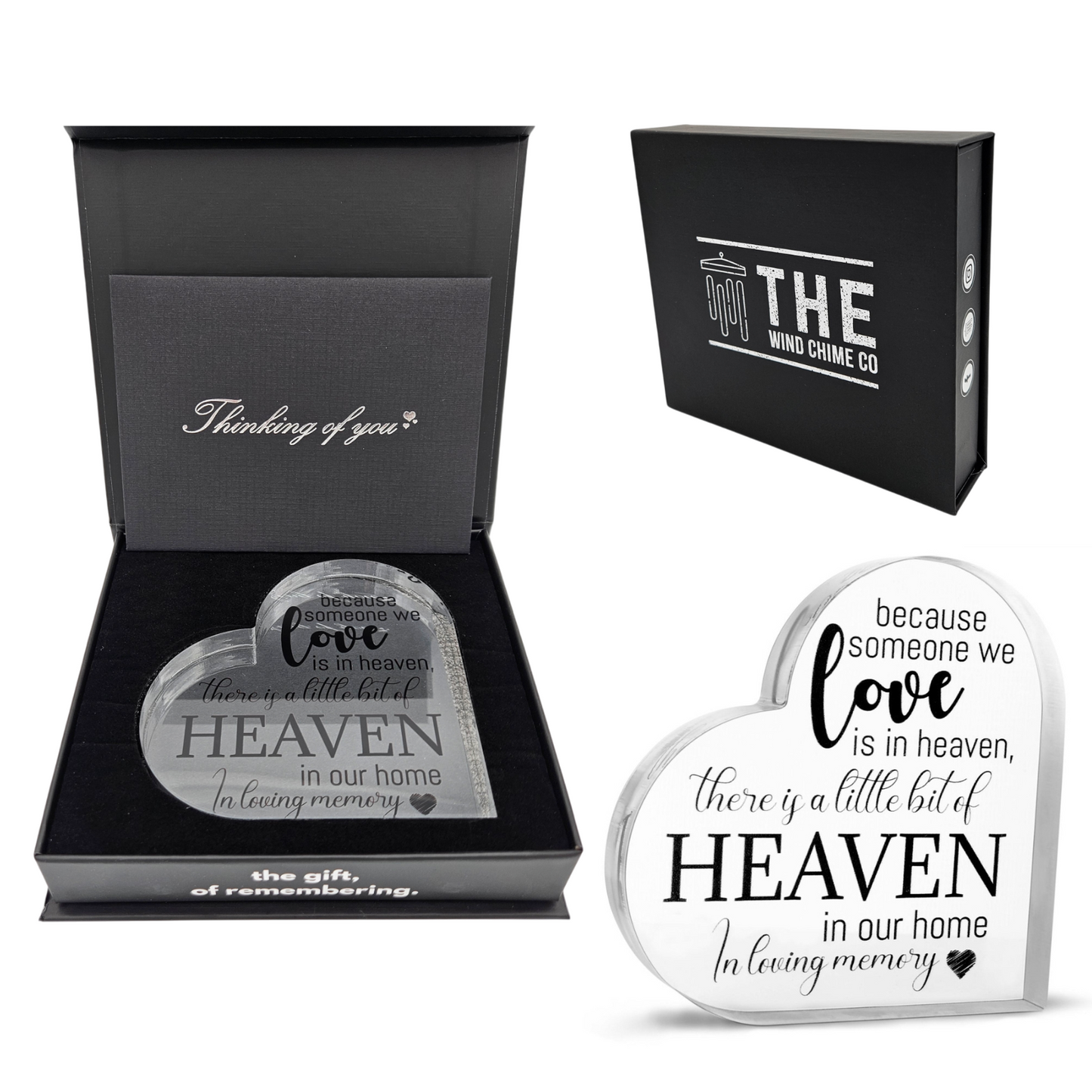 Acrylic memorial heart ornament with "Heaven In Our Home" inscription, designed by The Wind Chime Co, resting on a wooden surface.
