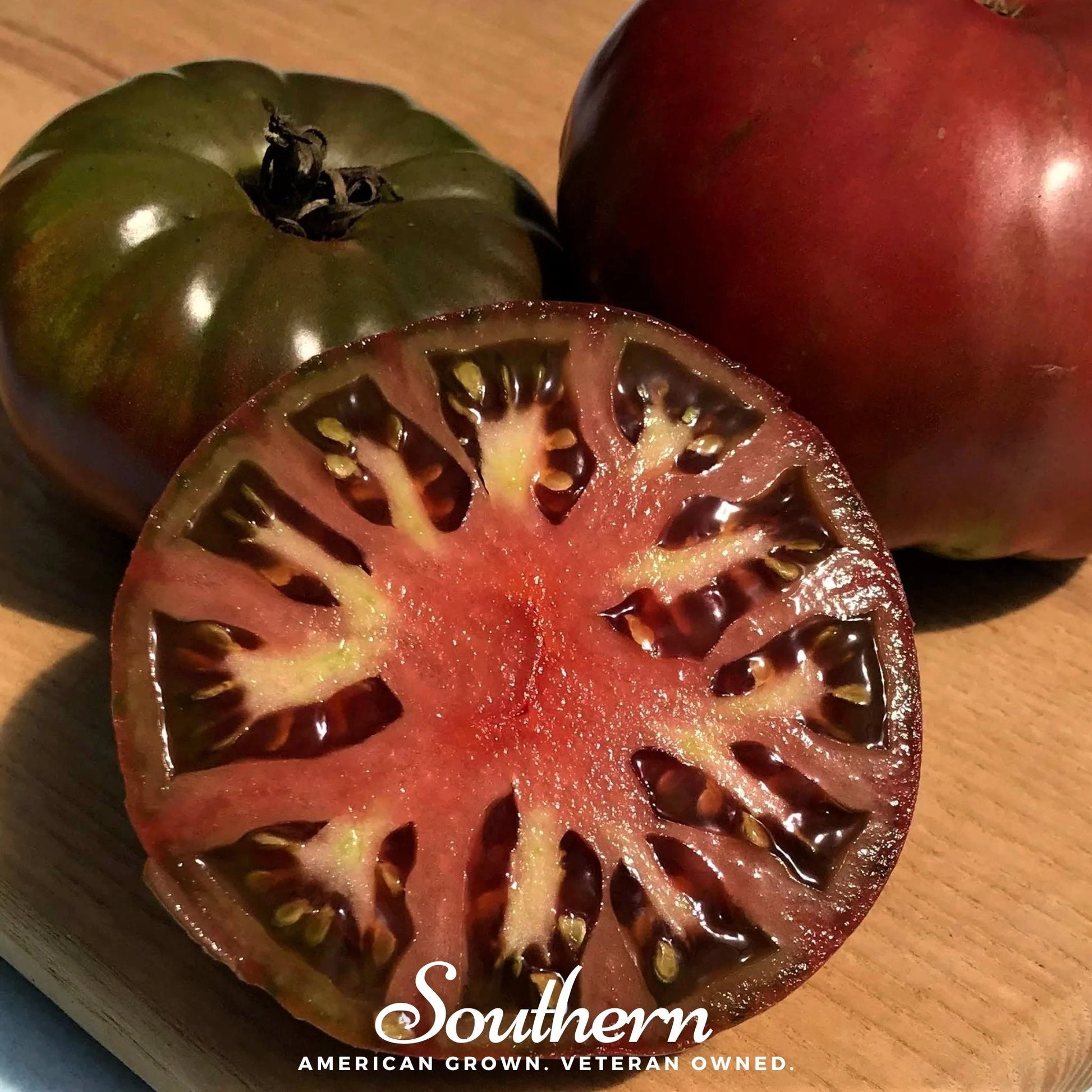Cherokee Purple Tomato seeds from Southern Seeds, showing ripe purple heirloom tomatoes on the vine.
