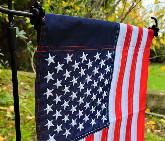 U.S. Garden Flag by Flagman of America with patriotic American flag design, made in the USA, displayed outdoors in a garden setting.