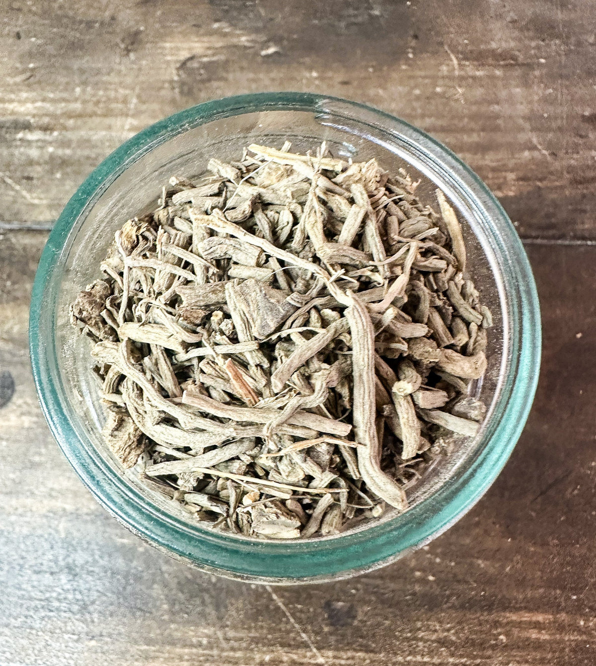 Small jar of dried valerian root herbs in an herbalroseapothecary herb jar, showcasing herbal remedy packaging.