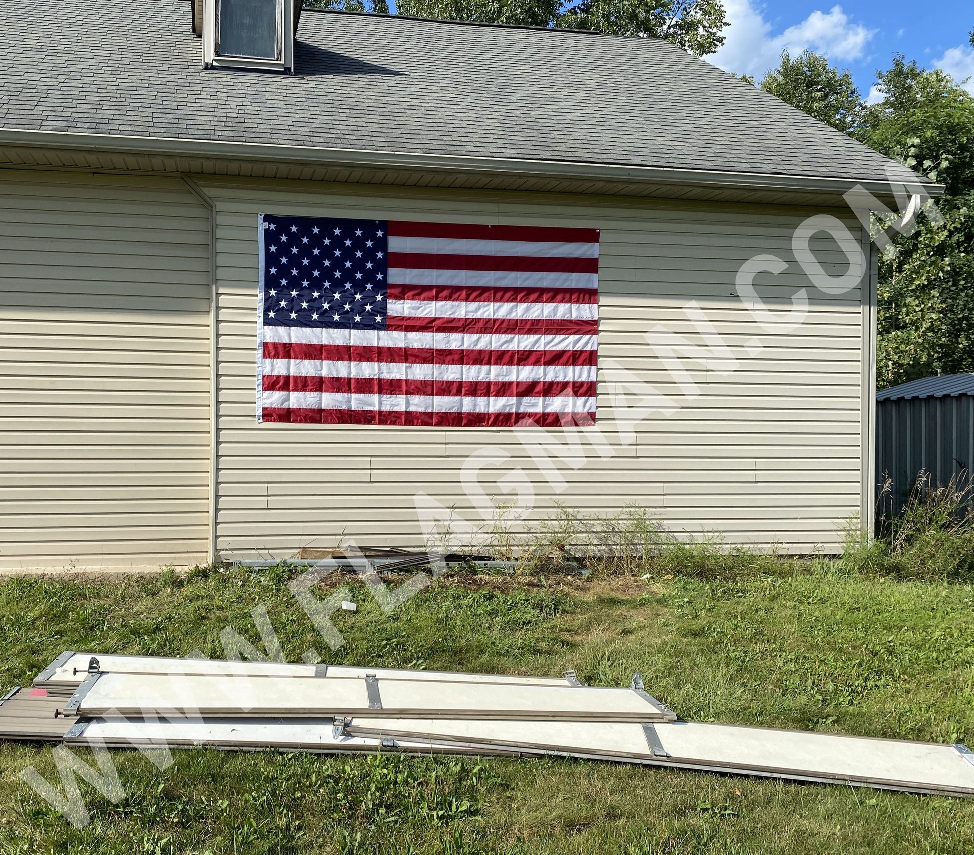 Nylon American flag wall hanging with reinforced edge grommets, mounted on wall, made in the USA by Flagman of America.