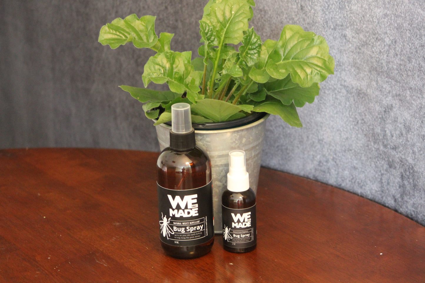 2 oz. bottle of WE Made bug spray with spray nozzle, designed to repel insects and protect outdoor activities.