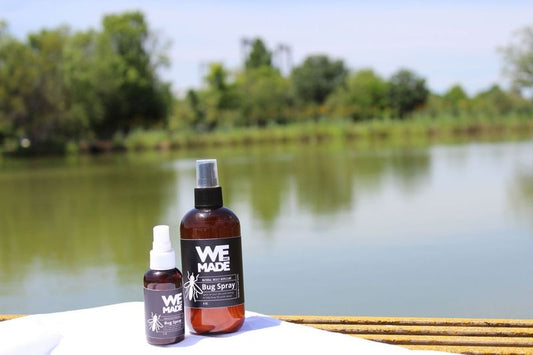Bottle of WE Made natural insect repellent bug spray, with spray nozzle and label indicating organic ingredients.