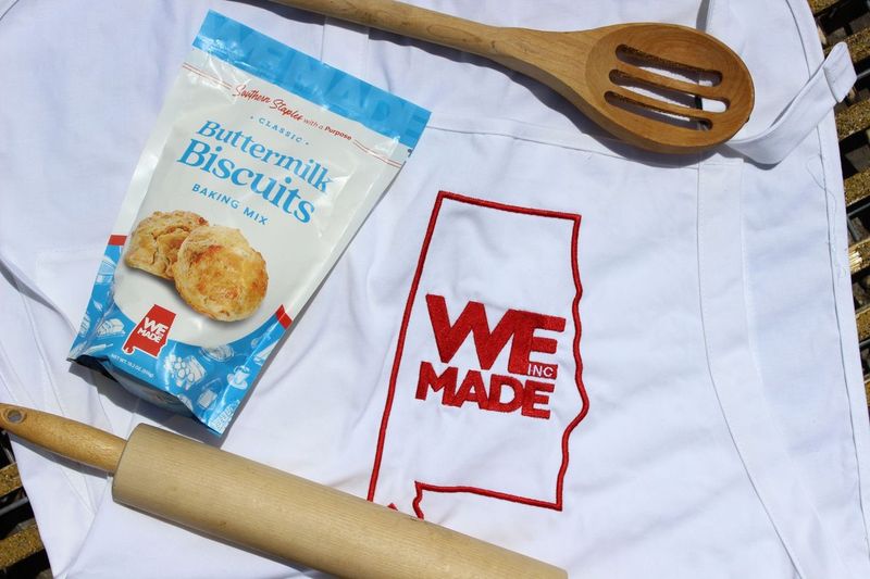 Bag of WE Made Buttermilk Biscuit Mix showing golden biscuits and the product label on the packaging.