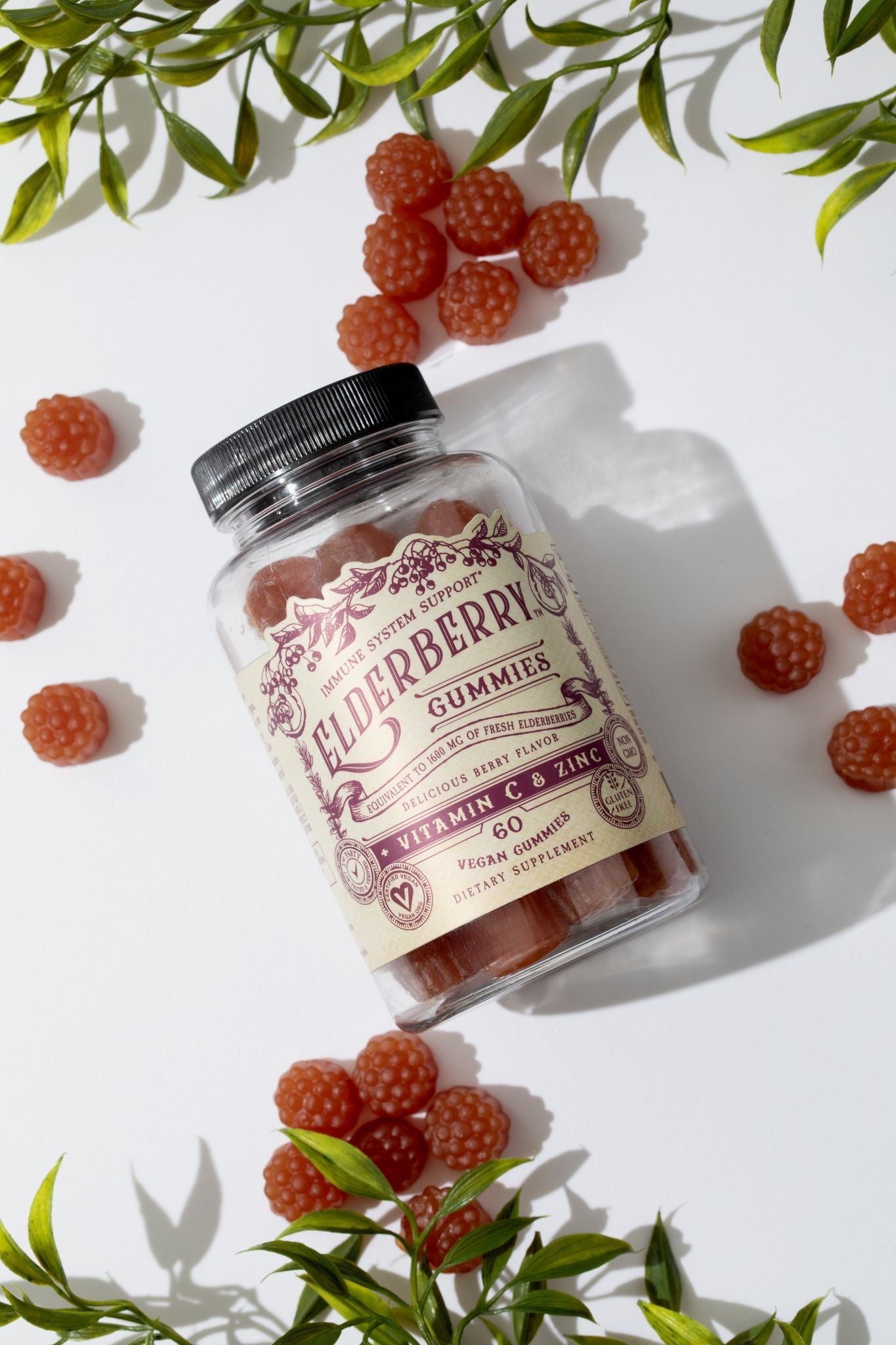 Elderberry gummies with vitamin C and zinc by Roots and Leaves LLC, shown in a clear container with fresh elderberries and citrus fruits.