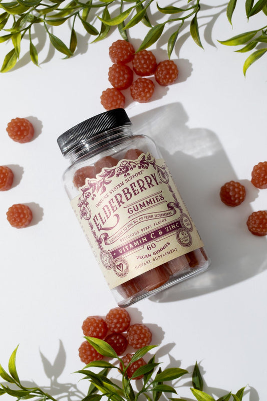 Elderberry gummies with vitamin C and zinc by Roots and Leaves LLC, shown in a clear container with fresh elderberries and citrus fruits.