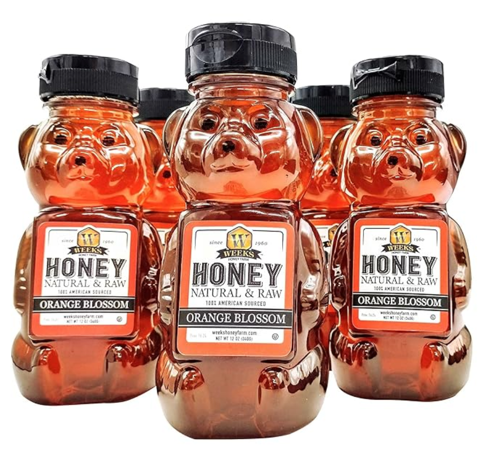 Jar of Weeks Naturals raw orange blossom honey with golden honey drizzling, highlighting its natural, pure honey appearance.